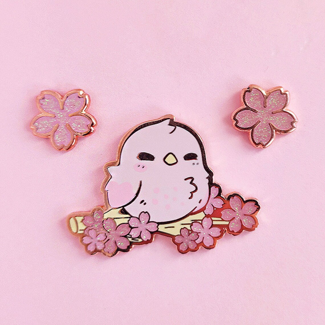 An enamel pin of a pink bird.